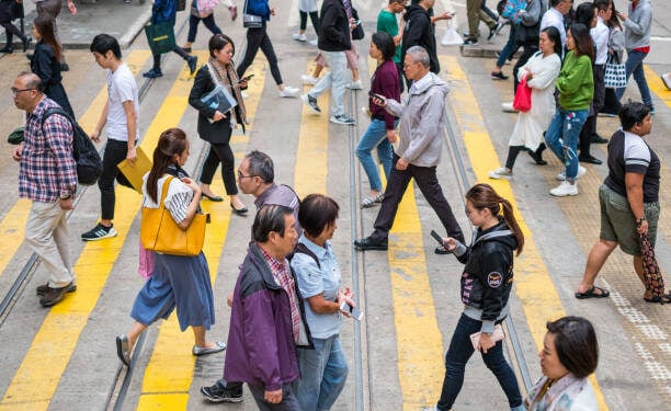 HongKong, China - November, 2019: People crossing street in crowded shopping district of HongKong City