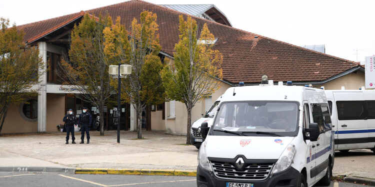 French CRS policemen stand next to CRS vehicles in front of a middle school in Conflans Saint-Honorine, 30kms northwest of Paris, on October 17, 2020, after a teacher was decapitated by an attacker who has been shot dead by policemen. - The man suspected of beheading on October 16 ,2020 a French teacher who had shown his students cartoons of the prophet Mohammed was an 18-year-old born in Moscow and originating from Russia's southern region of Chechnya, a judicial source said on October 17. Five more people have been detained over the murder on October 16 ,2020 outside Paris, including the parents of a child at the school where the teacher was working, bringing to nine the total number currently under arrest, said the source, who asked not to be named. The attack happened at around 5 pm (1500 GMT) near a school in Conflans Saint-Honorine, a western suburb of the French capital. The man who was decapitated was a history teacher who had recently shown caricatures of the Prophet Mohammed in class. (Photo by Bertrand GUAY / AFP)