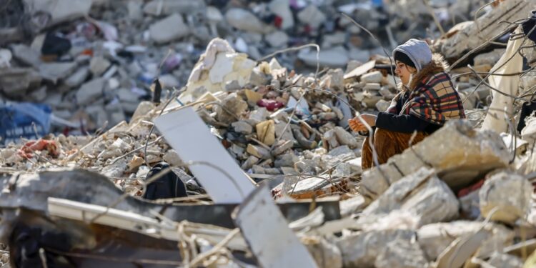 -FOTODELDIA- Samandag (Turquía), 18/02/2023.- Una mujer se sienta este sábado entre los escombros producidos por el terremoto que asoló el país en la localidad de Samandag. Al menos 44.000 personas han muerto tras el terremoto del pasado 6 de febrero. EFE/ Hannibal Hanschke