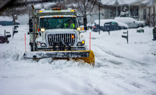 Heavy equipment driver working to push snow to the side of the streets after a blizzard