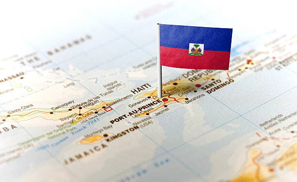 The flag of Haiti pinned on the map. Horizontal orientation. Macro photography.