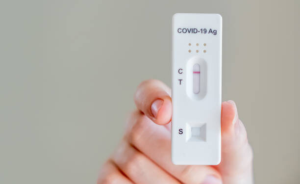 Hands holding Covid-19 rapid antigen test cassette with negative result of rapid diagnostic test at home