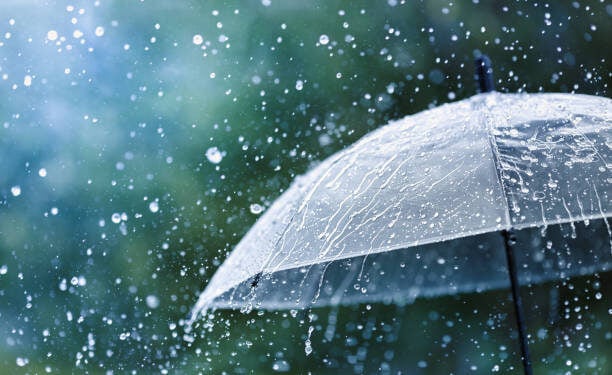 Transparent umbrella under heavy rain against water drops splash background. Rainy weather concept.