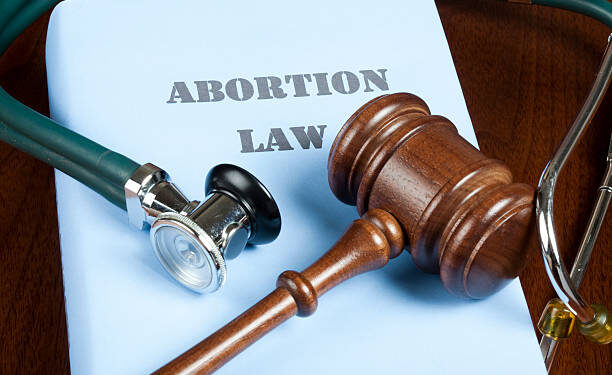 Gavel and stethoscope on Abortion law handbook.