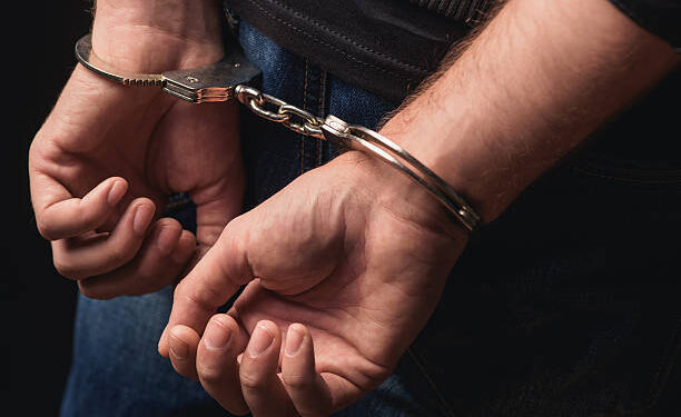 Close up of male hands in bracelets behind back