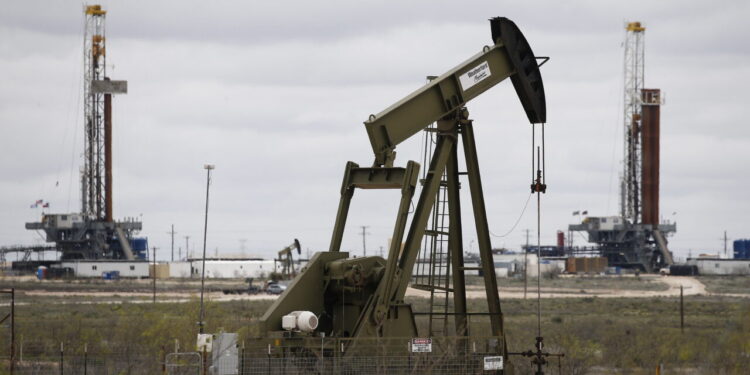 Midland (United States), 06/04/2020.- Two oil drilling rigs in background behind a pump jack in an oil field near Midland, Texas, USA, 06 April 2020. Midland, a city in western Texas, part of the Permian Basin area. Gas prices across the country are extremely low causing oil prices to drop dramatically in part due to the COVID-19 coronavirus. (Estados Unidos) EFE/EPA/LARRY W. SMITH
