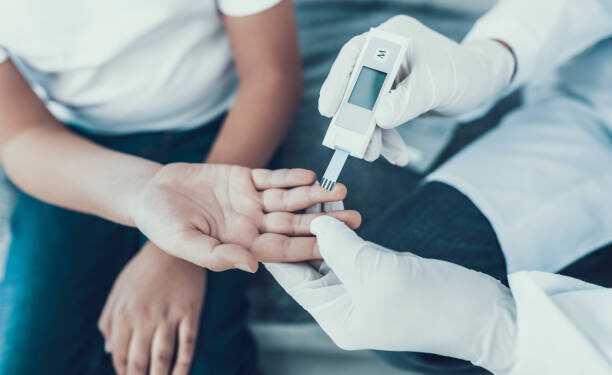 Doctor Taking Blood Sample from Boy's Finger. Diabetes Concept. Sugar in Blood. Healthcare Concept. Young Man in Uniform. White Coat. Medical Equipment. Boy in Clinic. Glucometer in Hand.