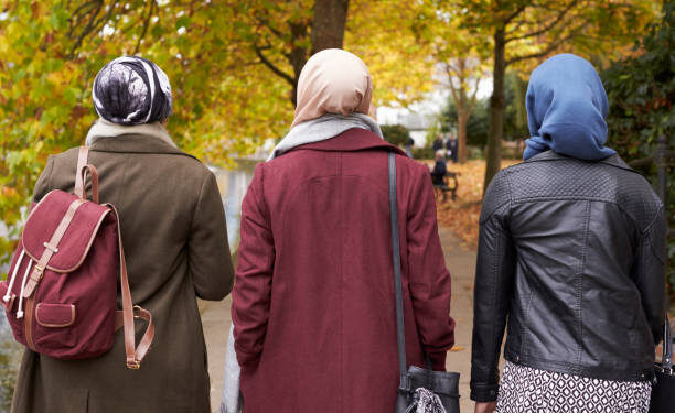 British Muslim Female Friends Walking In Urban Environment