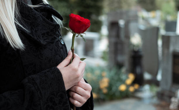 Woman with red flower at cemetery