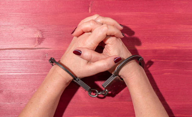 female hands in metal black handcuffs