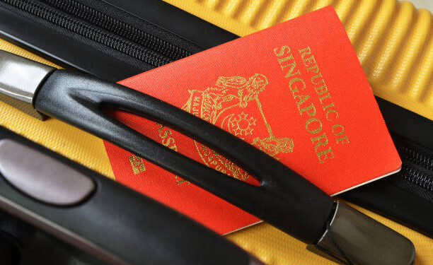 Singapore passport on a yellow suitcase. Travel concept