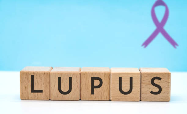 lupus text concept with letters on wooden block cubes on blue background with copy space