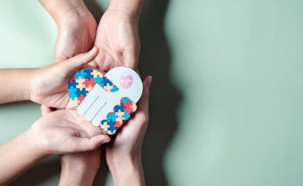 Father, Mother, Children holding heart jigsaw puzzle, Color puzzle symbol of awareness for autism spectrum disorder family support. Autism World Awareness Day.