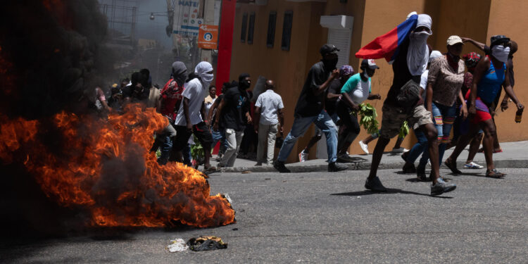 Manifestantes pasan junto a una barricada en llamas durante una marcha para exigir seguridad contra las pandillas, en Puerto Príncipe (Haití), en una fotografía de archivo. EFE/Johnson Sabin