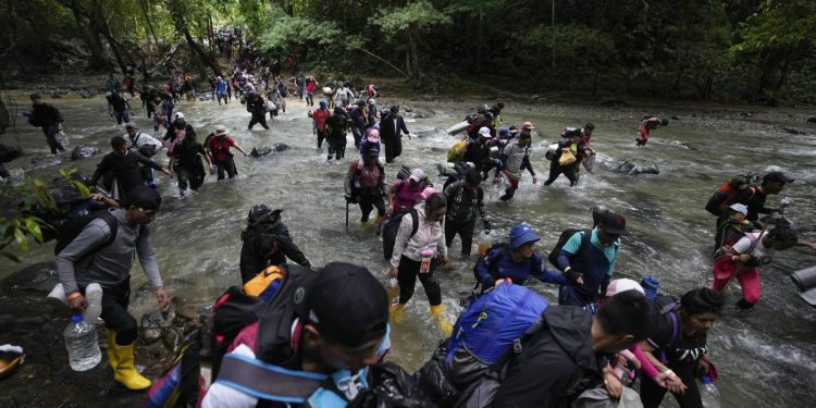 ARCHIVO - Migrantes, en su mayoría venezolanos, cruzan un río en la selva del Darién el 15 de octubre de 2022, en un recorrido de Colombia a Panamá, con la esperanza de seguir luego su viaje hacia Estados Unidos. La Agencia de la ONU para los Refugiados (ACNUR) y la Organización Internacional para las Migraciones (OIM) indicaron en un comunicado el jueves 13 de abril de 2023 que más 100.000 migrantes cruzaron esa ruta en los primeros meses del año y que, de seguir la tendencia, la cifra a final del año podría superar los 400.000. (AP Foto/Fernando Vergara, Archivo)