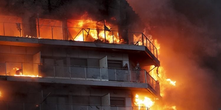 GRAFCVA8506. VALENCIA, 22/02/2024.- Dos personas aguardan en el balcón a ser rescatadas en el incendio declarado sobre las cinco y media de esta tarde en un quinto piso de un edificio de viviendas de València que ha afectado totalmente al inmueble y se ha propagado a otro anexo, y los bomberos intentan aún rescatar a vecinos desde los balcones. EFE/Manuel Bruque